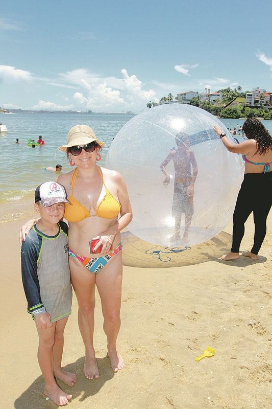 Alegria dentro da bolha: O pequeno João Vitor Silva, 7 anos, estava ansioso esperando sua vez para entrar na bolha que flutua sobre a água. Ele estava na praia com a mãe, a costureira Simone Silva, 44, que contou que a família é de Santa Catarina e  vai ficar até o dia 2 de janeiro aproveitando as praias do Estado. (Foto:  Leone Iglesias/AT)
